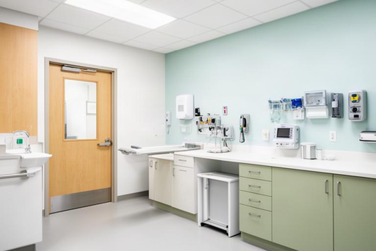 Bright clinic treatment room with durable hygienic finishes, accessible circulation and a fitted clinical work area